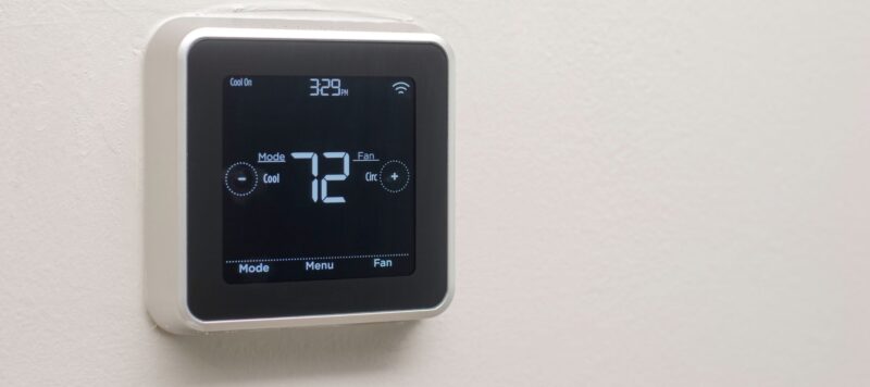 closeup of a smart thermostat on the wall showing 72 degrees