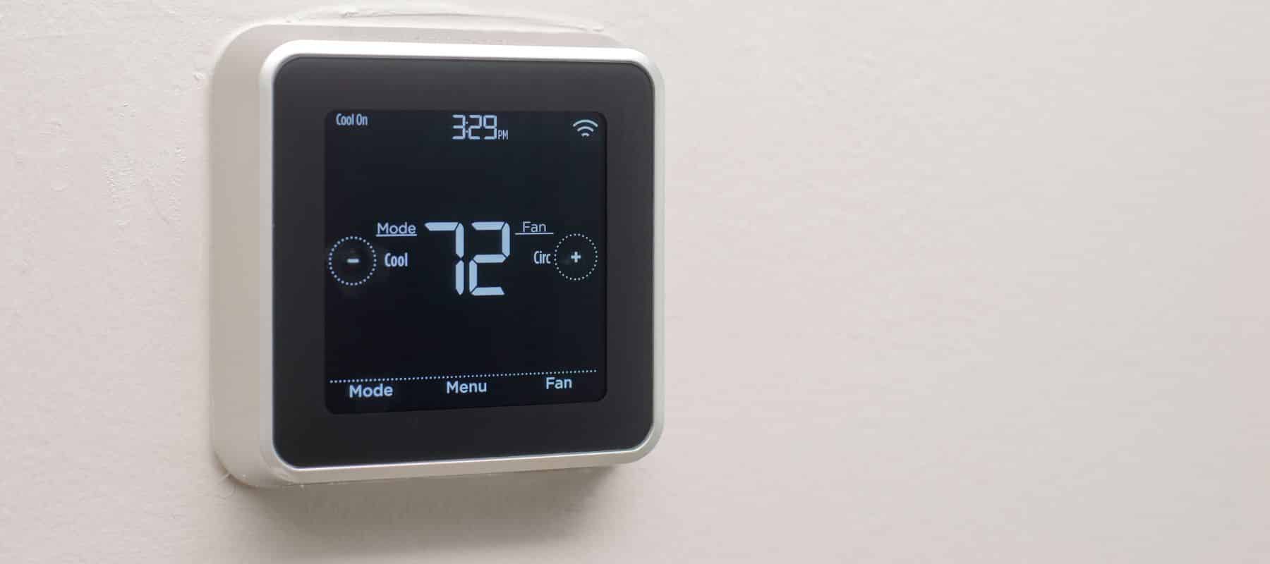 closeup of a smart thermostat on the wall showing 72 degrees